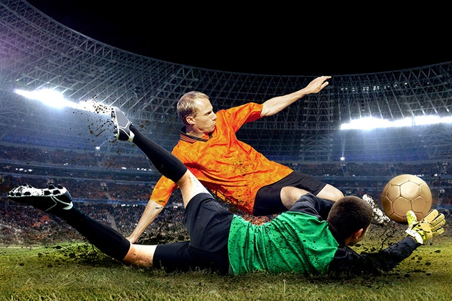 Dirt flies as the goalkeeper attempts to stop the ball